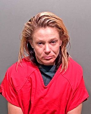 A woman with disheveled hair is shown wearing a red jail uniform, looking directly at the camera.
