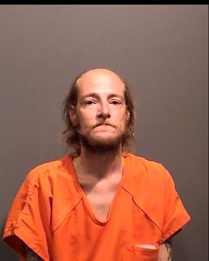A male inmate is shown wearing an orange jumpsuit and looking directly at the camera.