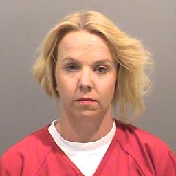 A woman with blonde hair is shown wearing a red prison jumpsuit, facing the camera.