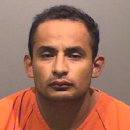 A man in an orange prison jumpsuit is shown in a mugshot.