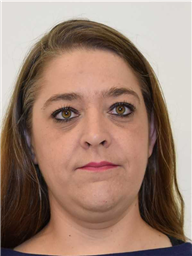 A woman with long brown hair and brown eyes is shown against a plain white background.