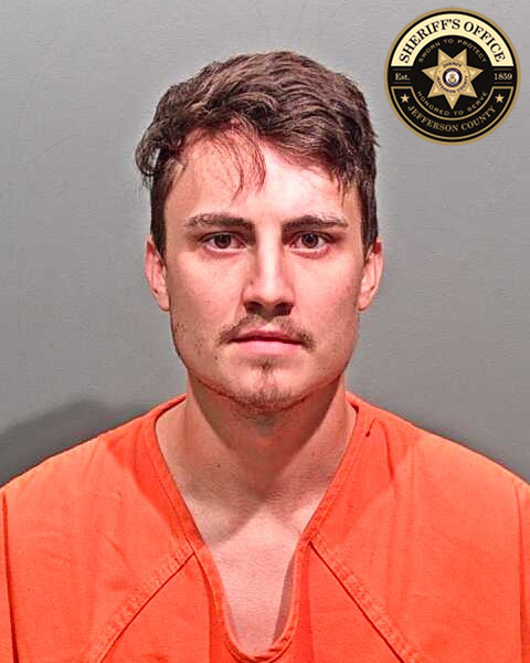White male with short brown hair, wearing an orange jail jumpsuit